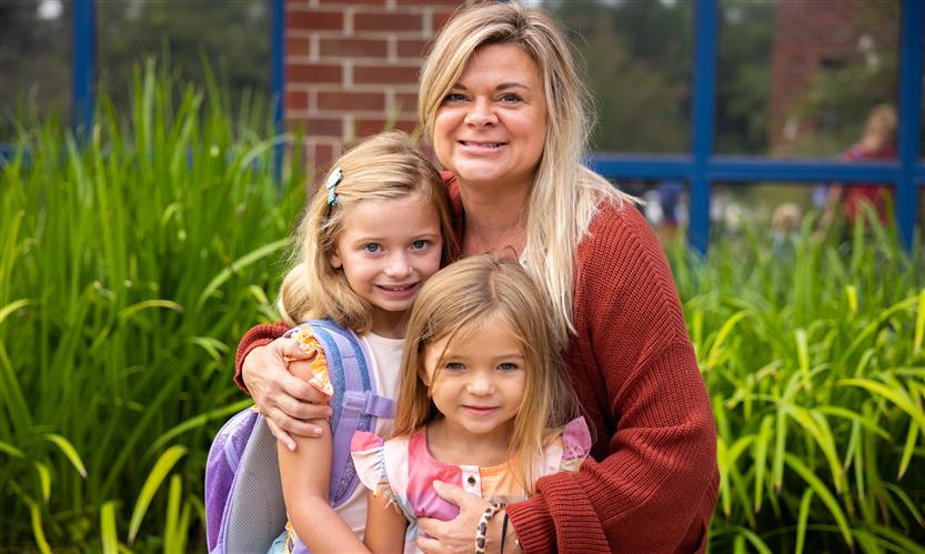 A mother and her two daughters smile